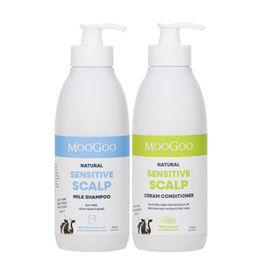 Two white pump bottles of MooGoo Natural Sensitive Scalp hair care products on a white background: Natural Sensitive Scalp Milk Shampoo with a blue label and Natural Sensitive Scalp Cream Conditioner with a green label. Natural scalp care duo for dry, flaky, irritated skin.